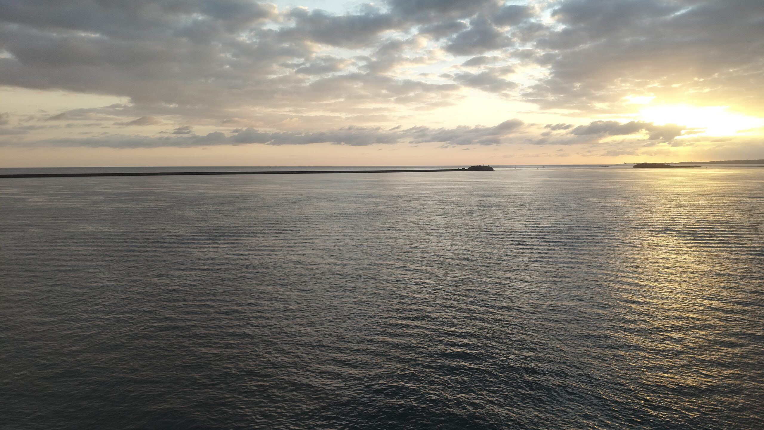 Sunrise over Cherbourg's breakwater on arrival